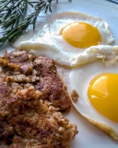 Plated and garnished goetta with fried eggs