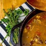 St. Kitts and Nevis Goat Water Stew in a cast iron dutch oven with parsley and thyme garnish