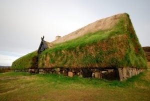 A photograph of Þjóðveldisbærinn in Iceland, a reconstruction of the Viking Longhouse Stöng. The building would have been the center of the farm of a Viking chief in middle ages and would have been used to store food. This replica adheres as closely as possible to the original way of building these longhouses, with a basic wood frame, stone base and turf walls/roof