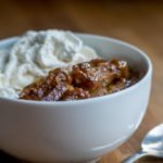30 degree view of Leftover Doughnut Praline Bread Pudding aka French Toast Casserole with whipped cream and a spoon